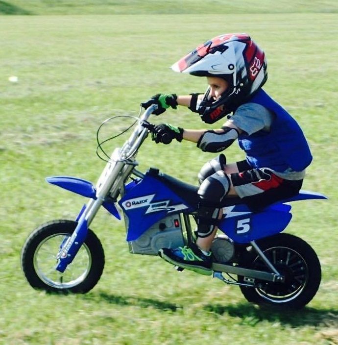 Boy wearing a blue Cool Kids cooling vest on a dirt bike