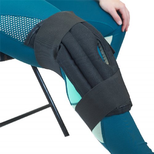 A woman wearing a Moist Heat Knee Wrap around her knee