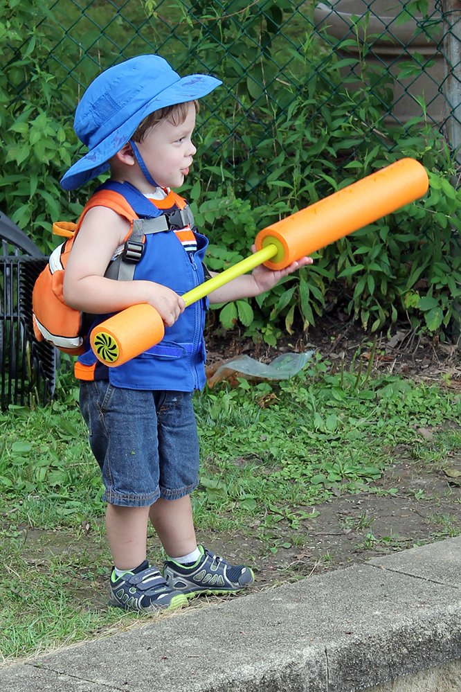 Boy with a water gun wearing a cool kids toddler cooling vest