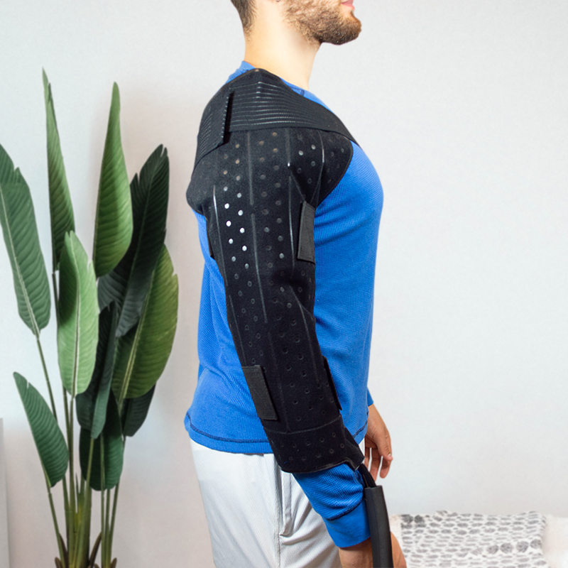 Athletic man wearing a large ice therapy cooling pack water pad compressed on his left shoulder