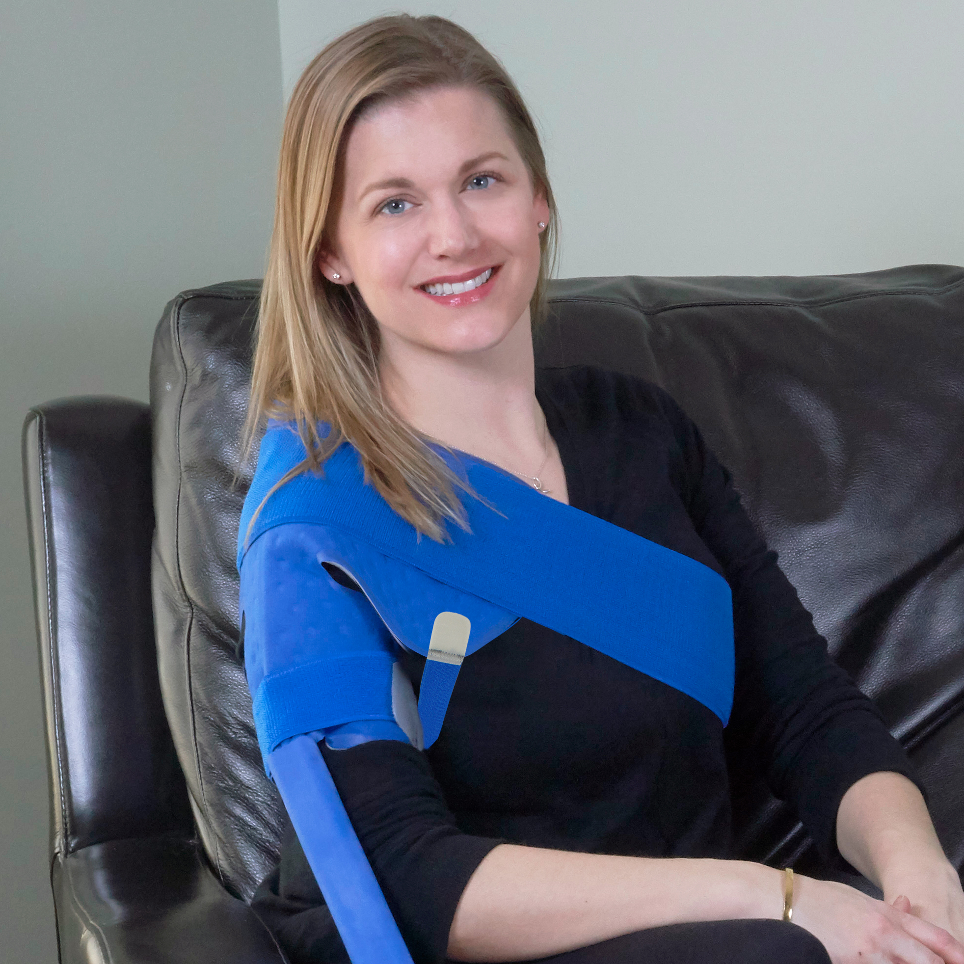 Woman wearing a ice cold therapy cooling pack water pad on her left shoulder