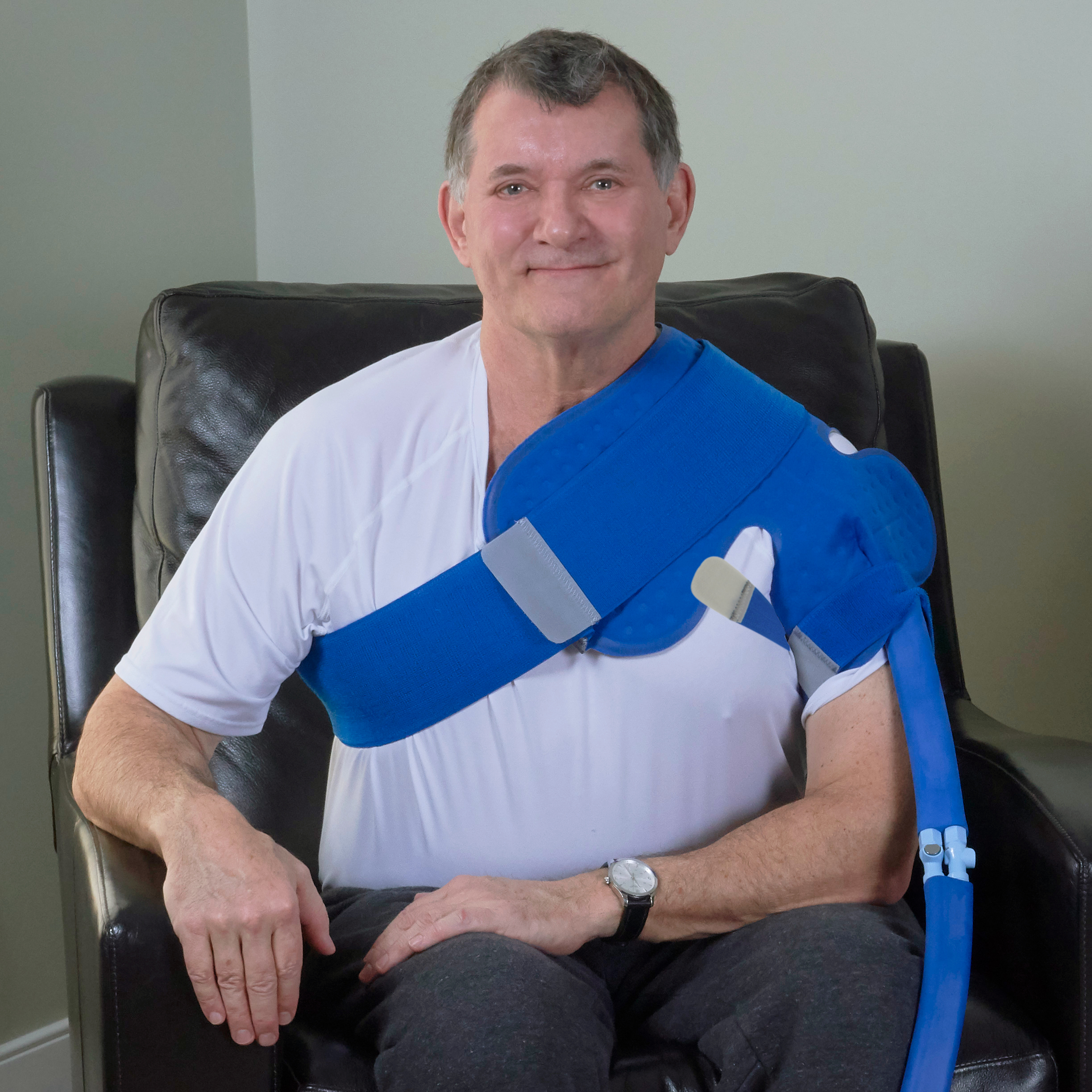 Man wearing a ice cold therapy cooling pack water pad on his left shoulder