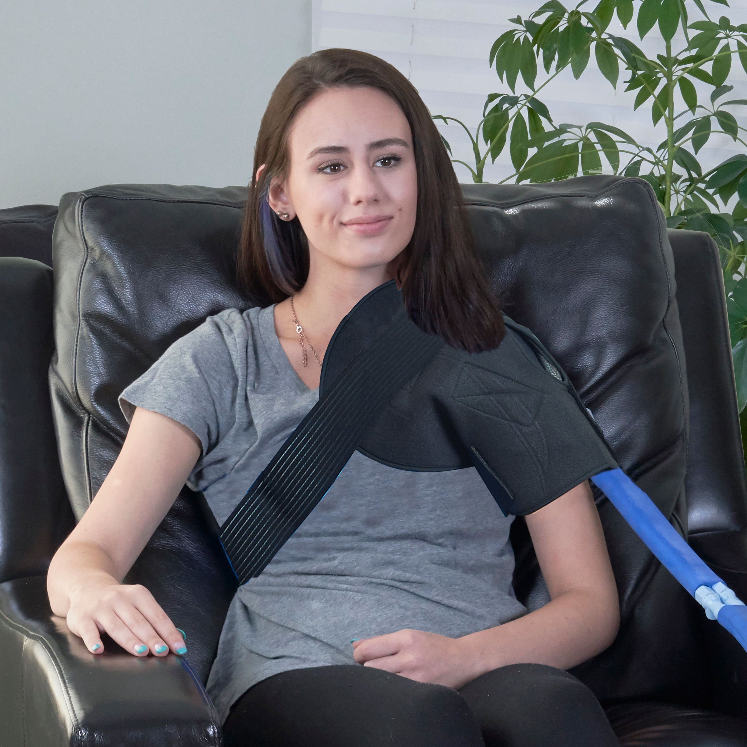 Young woman wearing a ice cold therapy cooling pack water pad on her left shoulder