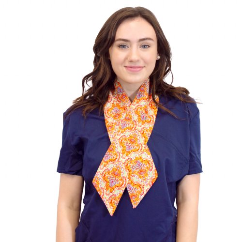 A woman in scrubs wearing an orange patterned fashion scarf