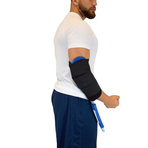 A man is standing facing a wall and a Universal Cold Water Therapy Bladder is attached to his elbow via Elbow Compression Wrap