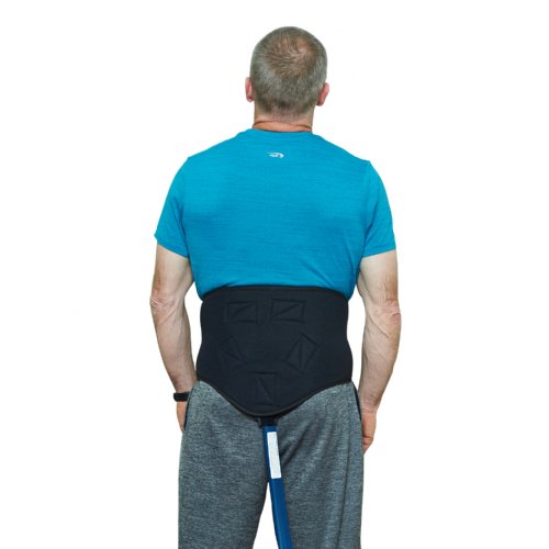 A man is standing and wearing a Universal Bladder the bladder is secured by a Lumbar and Back Compression Wrap 
