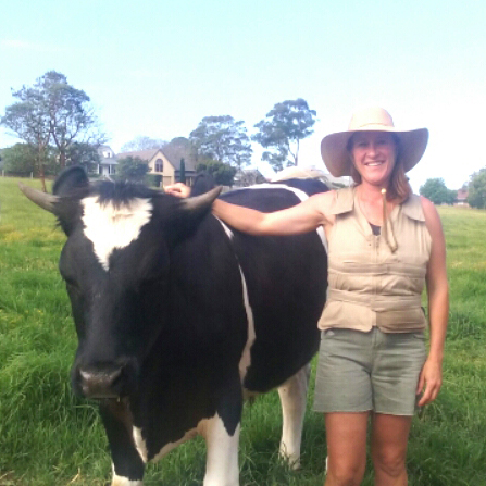 Woman wearing a khaki Kool Max adjustable zipper front cooling vest standing next to a cow