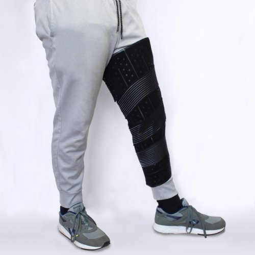 Athletic man wearing a large ice therapy cooling pack water pad compressed on his knee