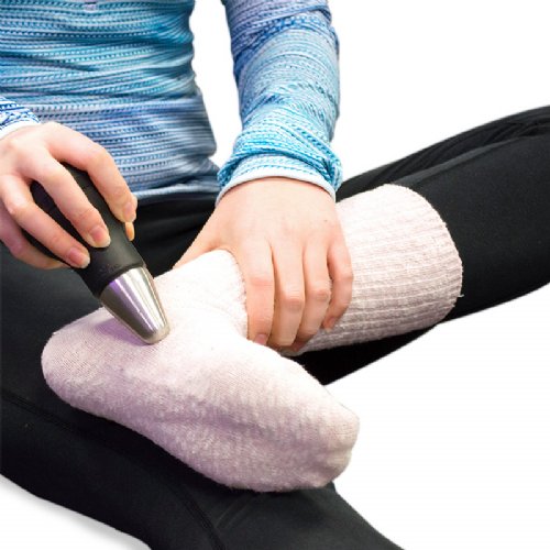a hand held deep tissue massager applied to the arch of an injured foot