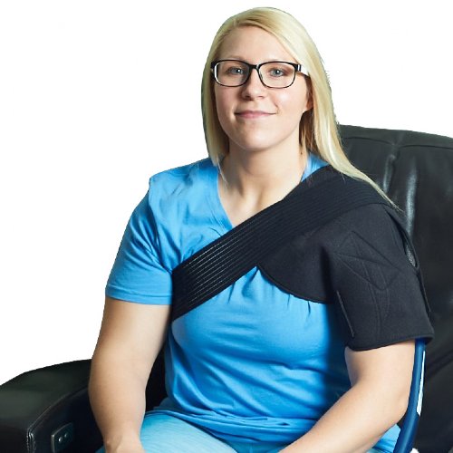 A woman is sitting down wearing an Active Ice3.0 Universal Bladder on her shoulder which is held in place by a comforting shoulder compression wrap 