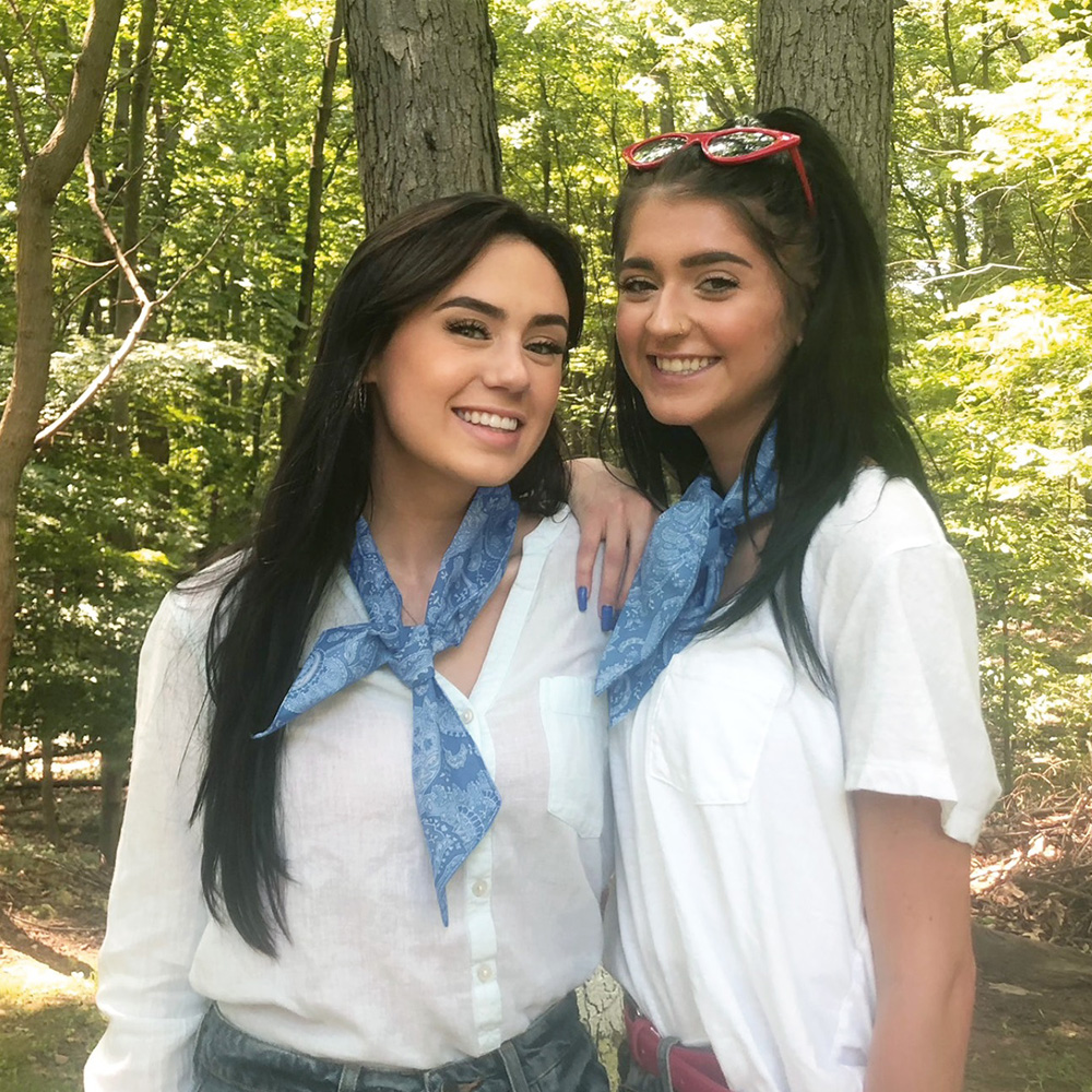 Two sisters wearing fashion scarves in the woods